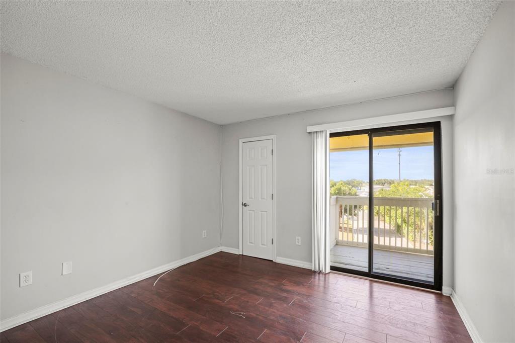 455 Alt 19, Unit 175 Palm Harbor, FL 34683 - Photo 24 of 35 an empty room with wooden floor and a window
