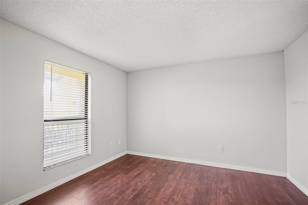 455 Alt 19, Unit 175 Palm Harbor, FL 34683 - Photo 25 of 35 an empty room with wooden floor and windows