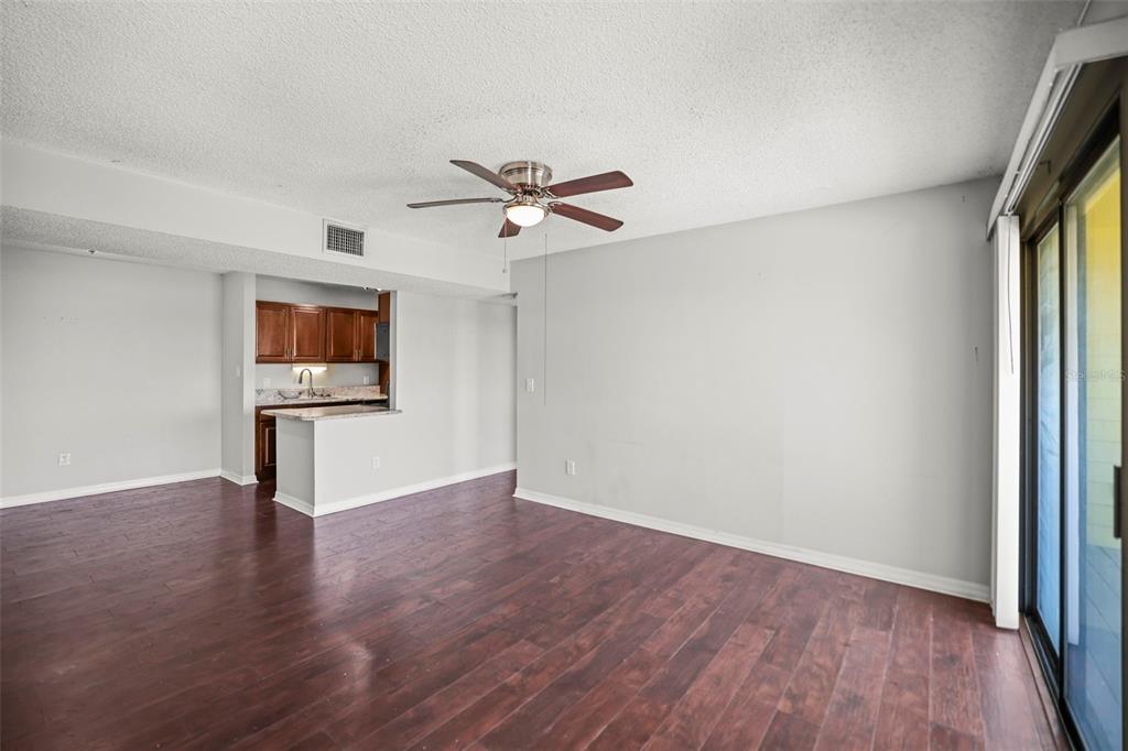 455 Alt 19, Unit 175 Palm Harbor, FL 34683 - Photo 5 of 35 a view of a kitchen with wooden floor and a ceiling fan