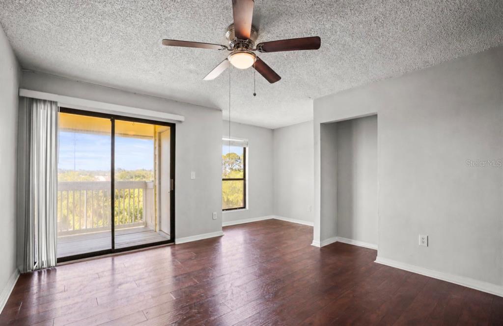 455 Alt 19, Unit 175 Palm Harbor, FL 34683 - Photo 7 of 35 an empty room with wooden floor fan and windows