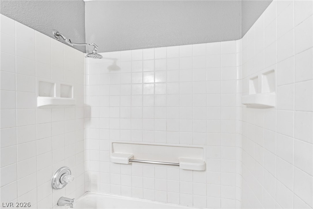 3318 North Decatur Boulevard, Unit 2152 Las Vegas, NV 89130 - Photo 27 of 58 A pristine shower and tub combination featuring white tile walls and contemporary fixtures awaits.