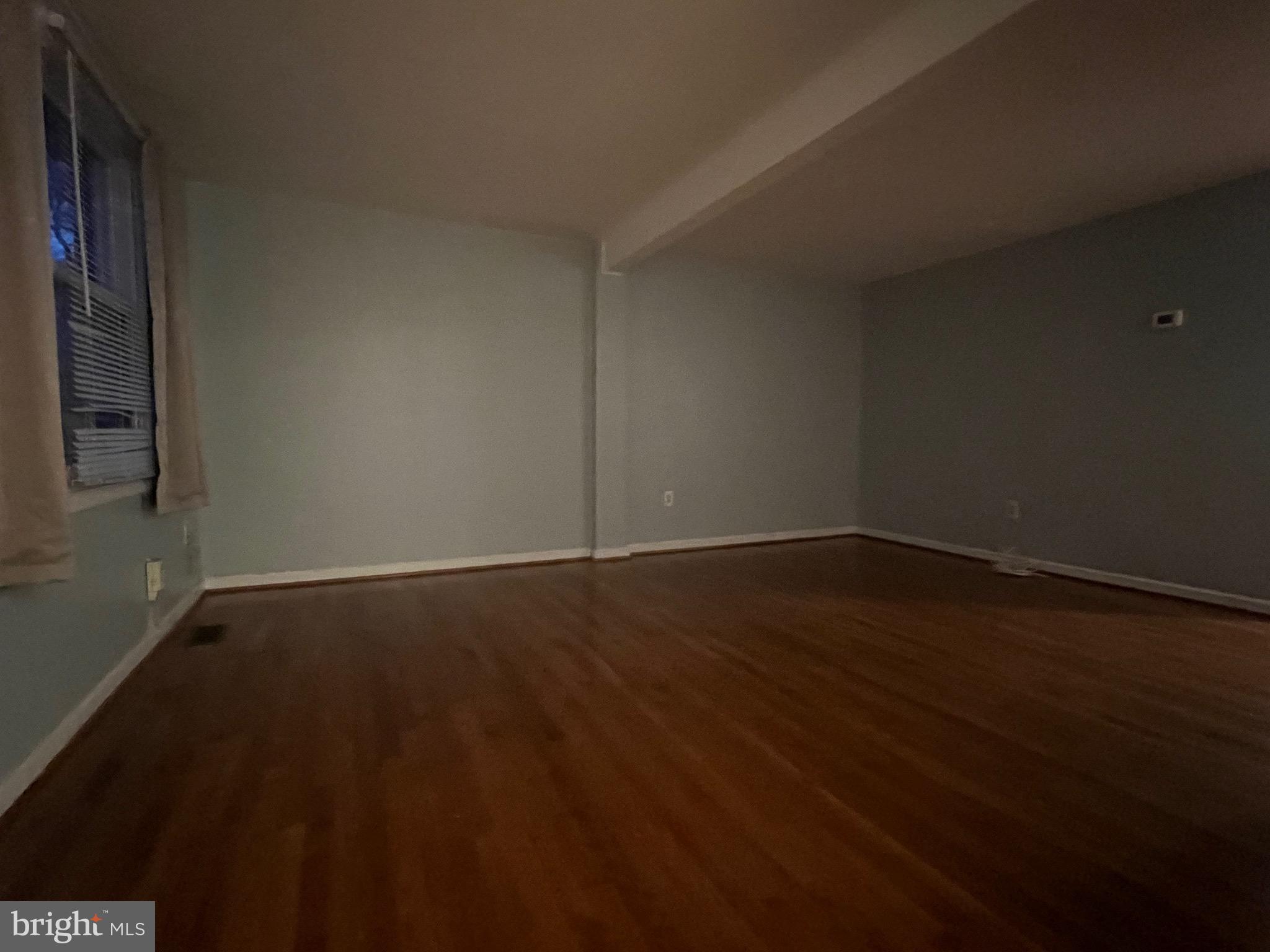 18804 Creeper Lane Gaithersburg, MD 20879 - Photo 2 of 20 a view of an empty room with wooden floor and a window