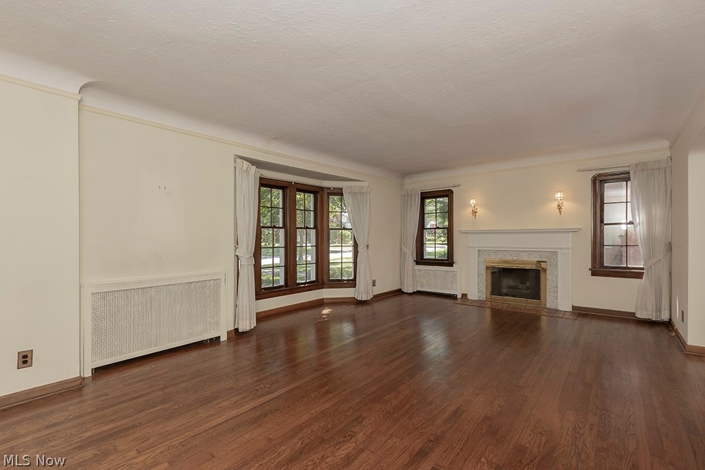 Living room with fireplace and lovely bay window.
