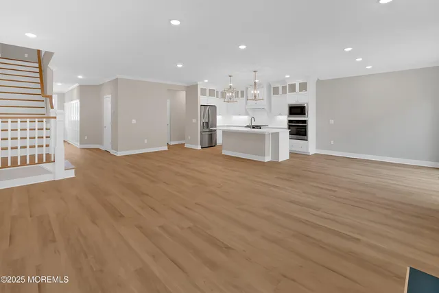 a large white kitchen with white cabinets and a wooden floor