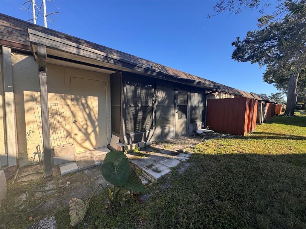 670 Green Valley Road, Unit F9 Palm Harbor, FL 34683 - Photo 19 of 22 a backyard of a house with wooden fence and a bench