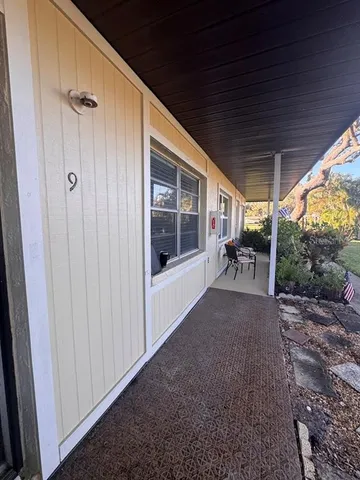 a view of a porch with chairs and backyard