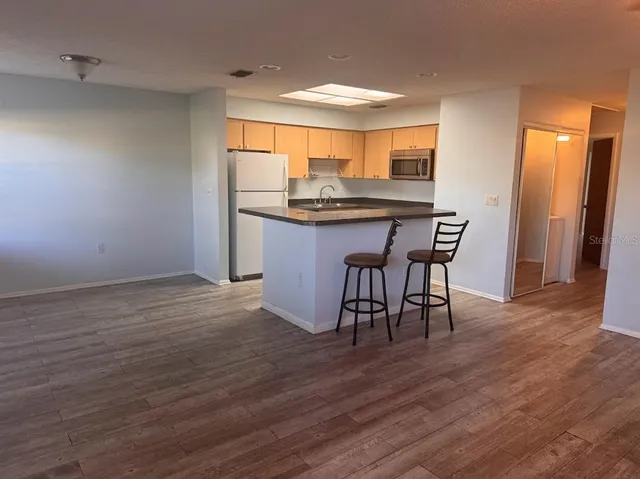 a kitchen with stainless steel appliances granite countertop a table chairs and a sink