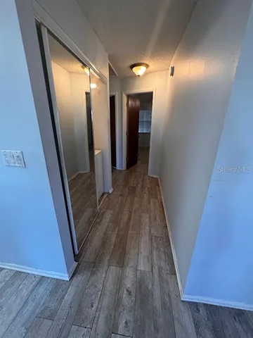 a view of hallway with wooden floor