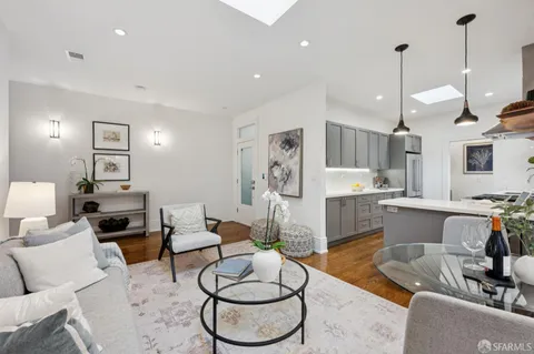 a living room with furniture a rug and kitchen view