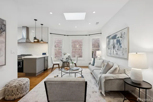 a living room with furniture and a view of kitchen