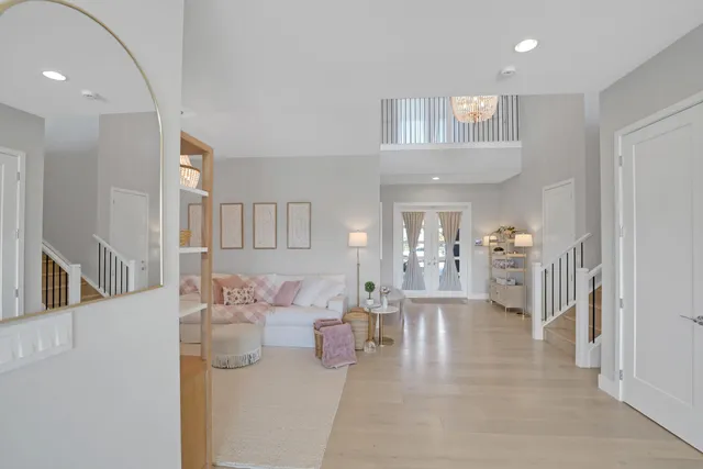 a bedroom with a bed chandelier and a window
