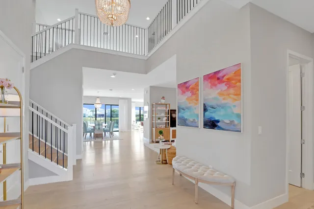 a view of a dining room with furniture large windows and a chandelier