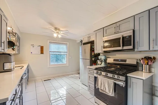 a kitchen with stainless steel appliances granite countertop a stove a sink and a microwave