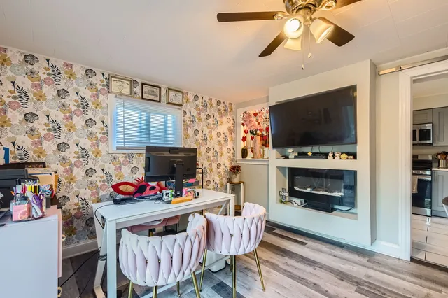 a living room with furniture a flat screen tv and a fireplace