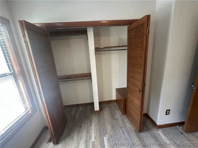 a kitchen with a refrigerator and wooden floor