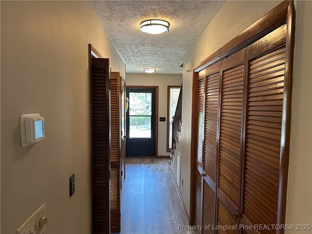 a view of a hallway with wooden floor and staircase