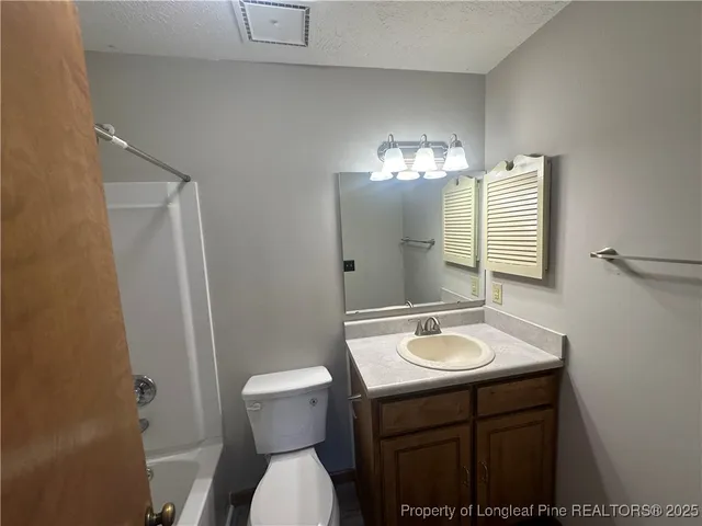 a bathroom with a sink and mirror with toilet