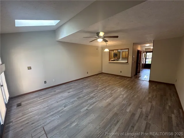 a view of a livingroom with wooden floor and a ceiling fan