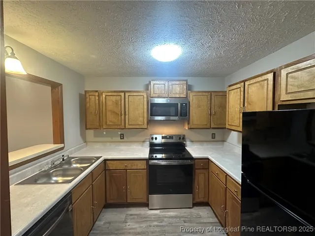 a kitchen with a sink stove and refrigerator