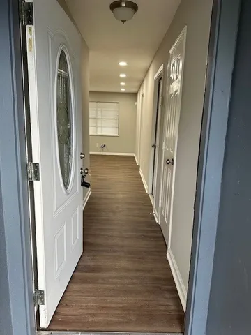 a view of a hallway with wooden floor and entryway