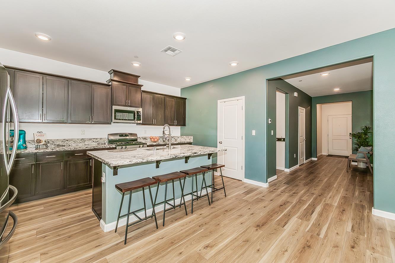 1428 Shoreside Drive Madera, CA 93637 - Photo 3 of 22 a kitchen with kitchen island granite countertop a stove and a wooden floors