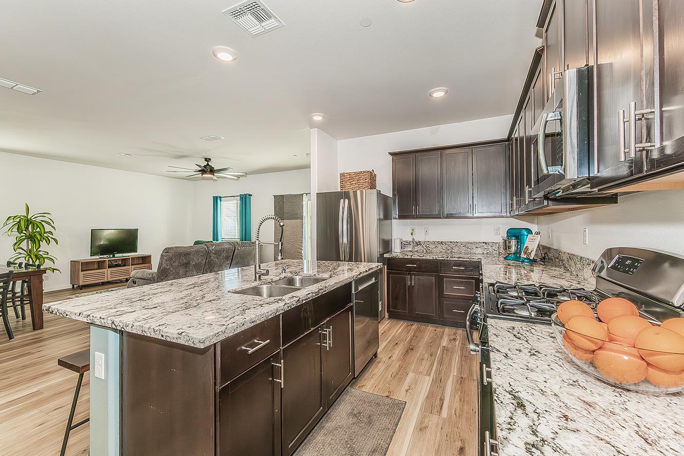 1428 Shoreside Drive Madera, CA 93637 - Photo 4 of 22 a kitchen with stainless steel appliances granite countertop a sink stove and refrigerator