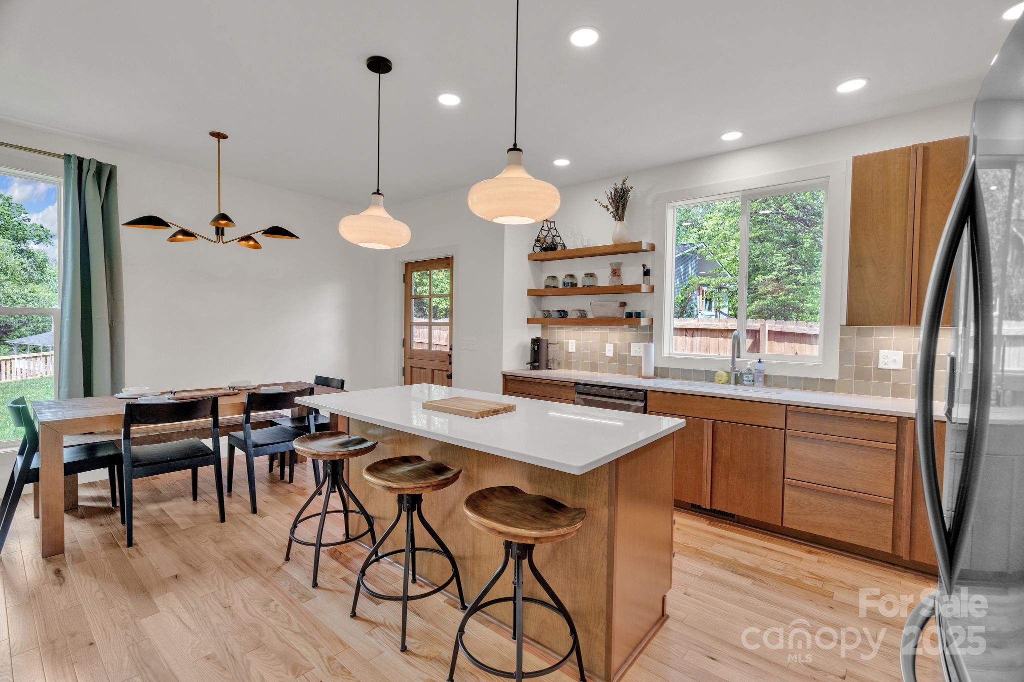 30 Spaulding Road Candler, NC 28715 - Photo 2 of 30 a kitchen with stainless steel appliances granite countertop a stove a refrigerator a kitchen island a dining table and chairs with wooden floor