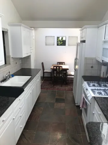 a kitchen with kitchen island a sink stove and refrigerator