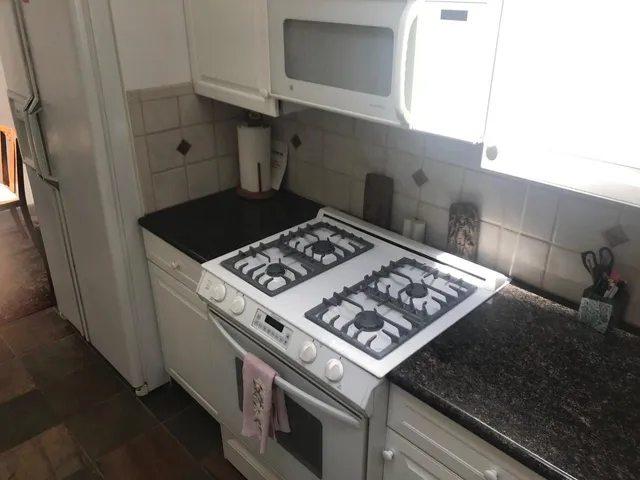 a stove top oven sitting inside of a kitchen