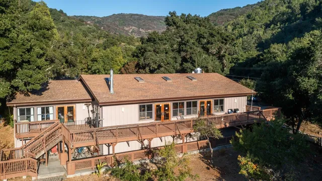 a aerial view of a house next to a yard with plants and trees