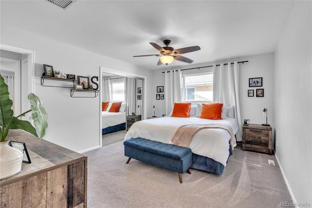 a spacious bedroom with a bed and a chandelier