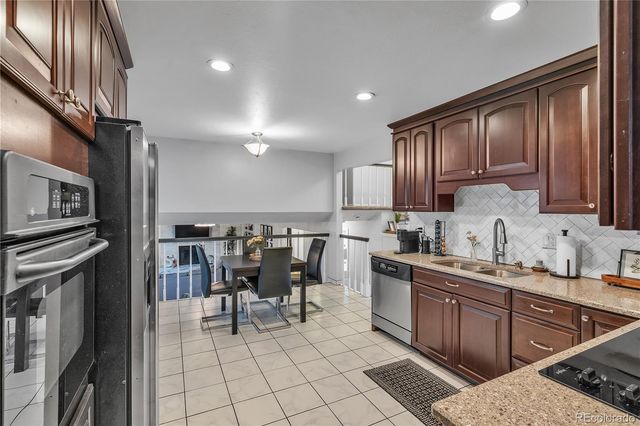 a kitchen with stainless steel appliances granite countertop a sink stove and cabinets
