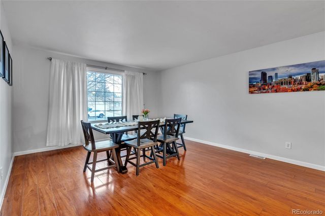 a dining room with furniture and wooden floor