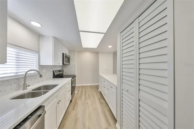 a view of a kitchen with a sink and cabinets