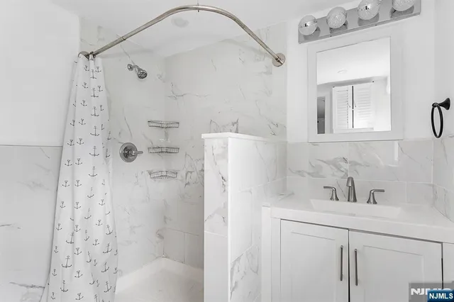 a bathroom with a sink a mirror a shower and vanity