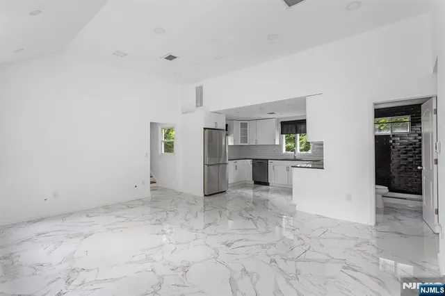 a view of a kitchen with refrigerator and windows