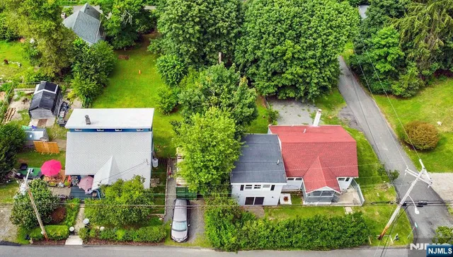 an aerial view of residential houses with outdoor space and trees