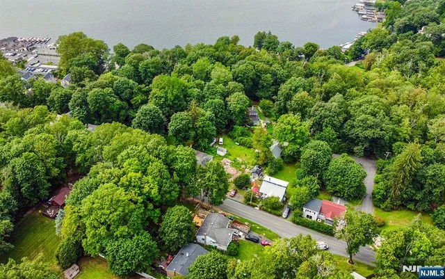 an aerial view of residential house with outdoor space and trees all around