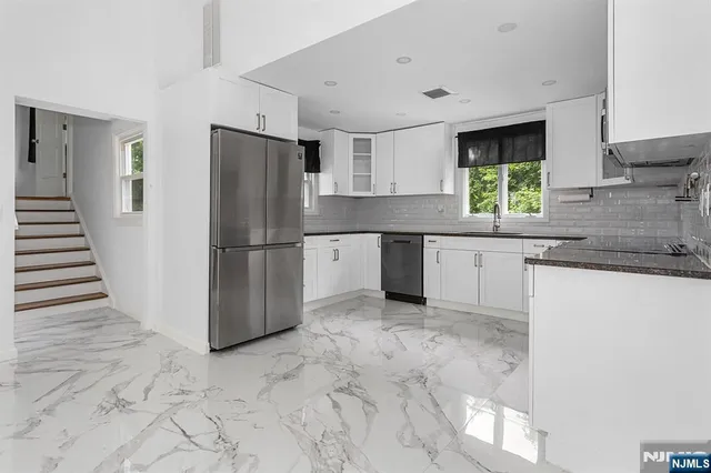 a kitchen with granite countertop a refrigerator and a sink