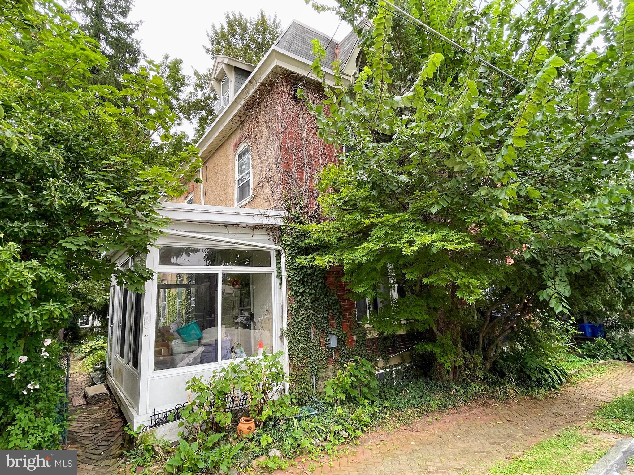 a view of a white house with large windows and plants