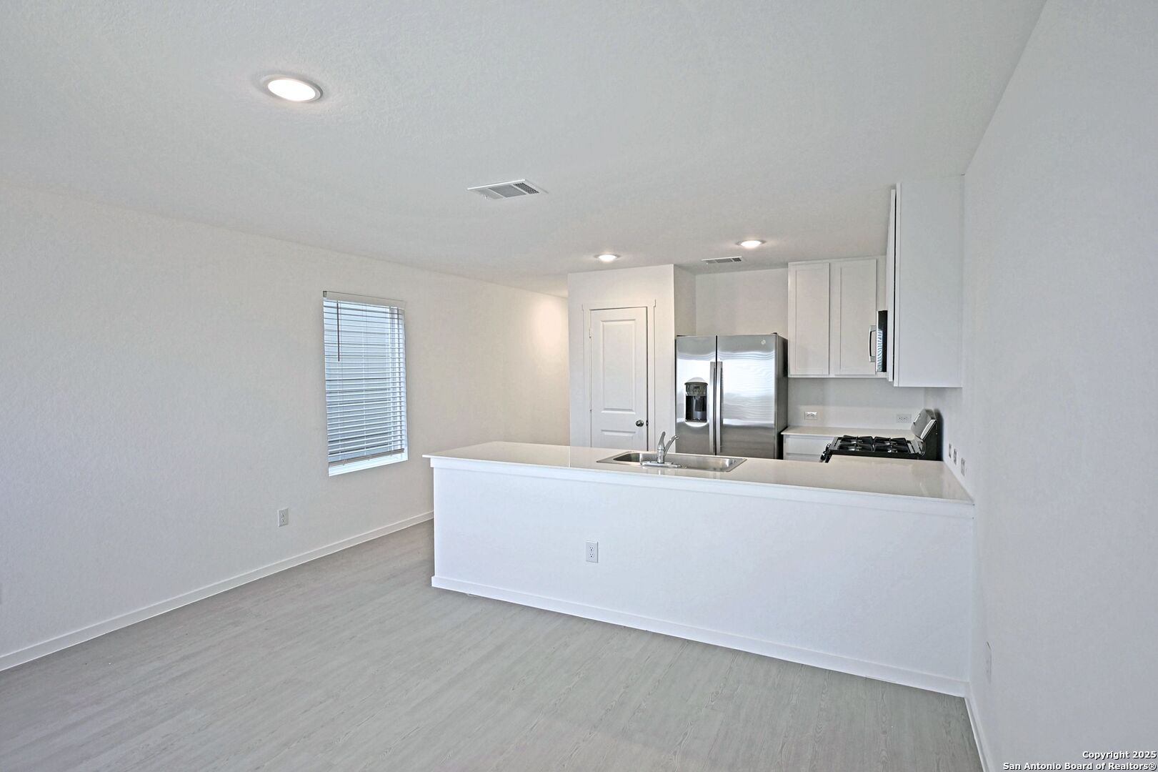 5014 Winecup Cove Converse, TX 78109 - Photo 12 of 25 a large white kitchen with kitchen island a sink stainless steel appliances and cabinets