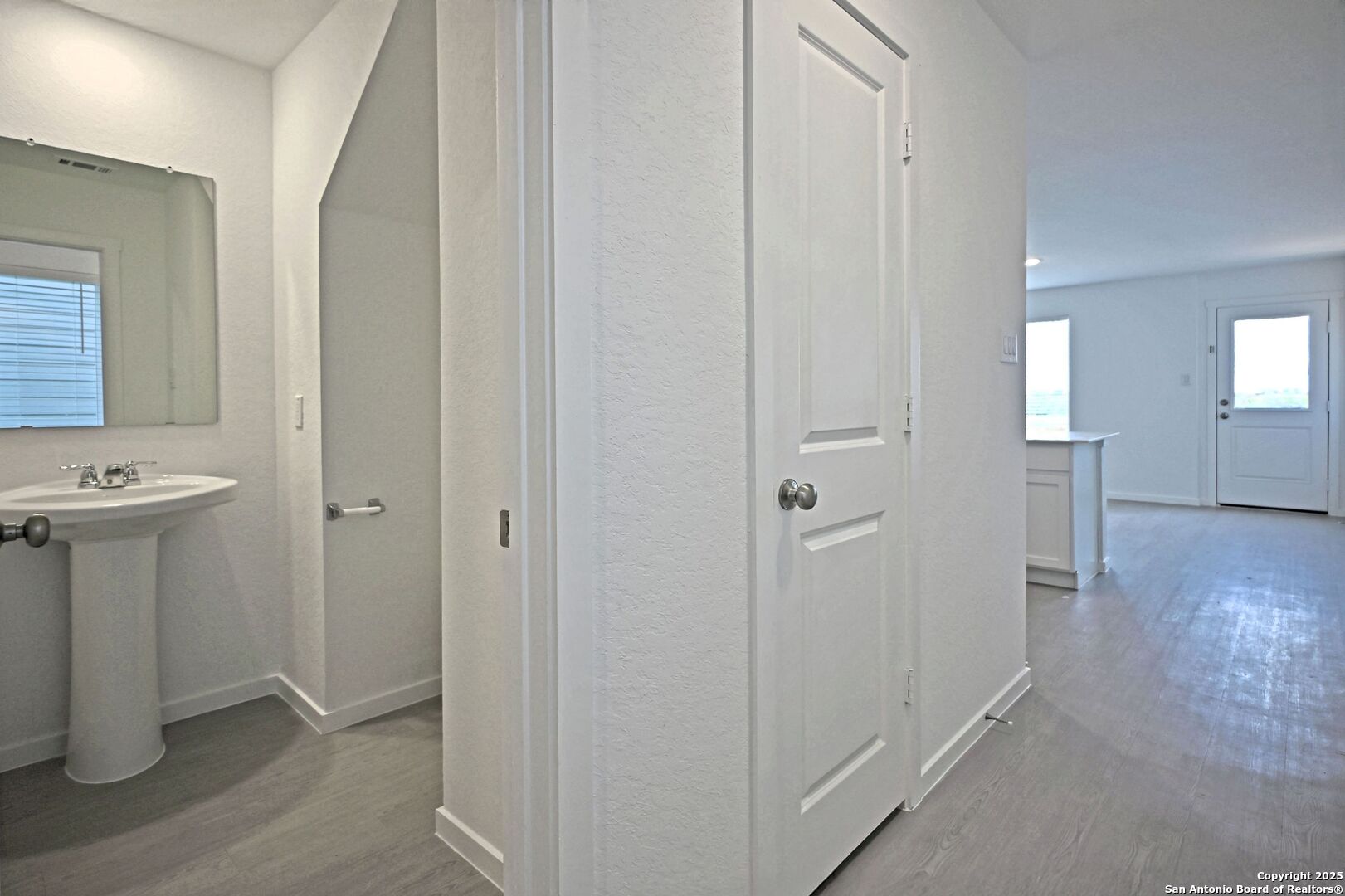 5014 Winecup Cove Converse, TX 78109 - Photo 3 of 25 a view of a hallway with wooden floor and a bathroom