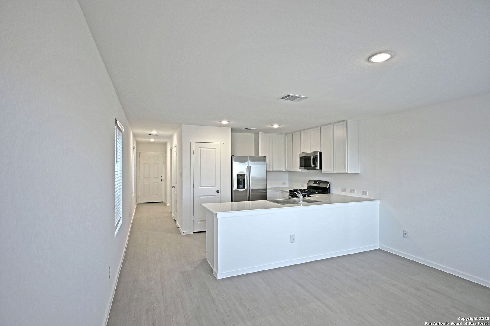 5014 Winecup Cove Converse, TX 78109 - Photo 7 of 25 a kitchen with stainless steel appliances a sink a stove a refrigerator and cabinets