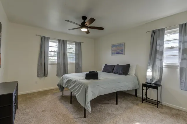 a bedroom with a bed a window and a flat screen tv