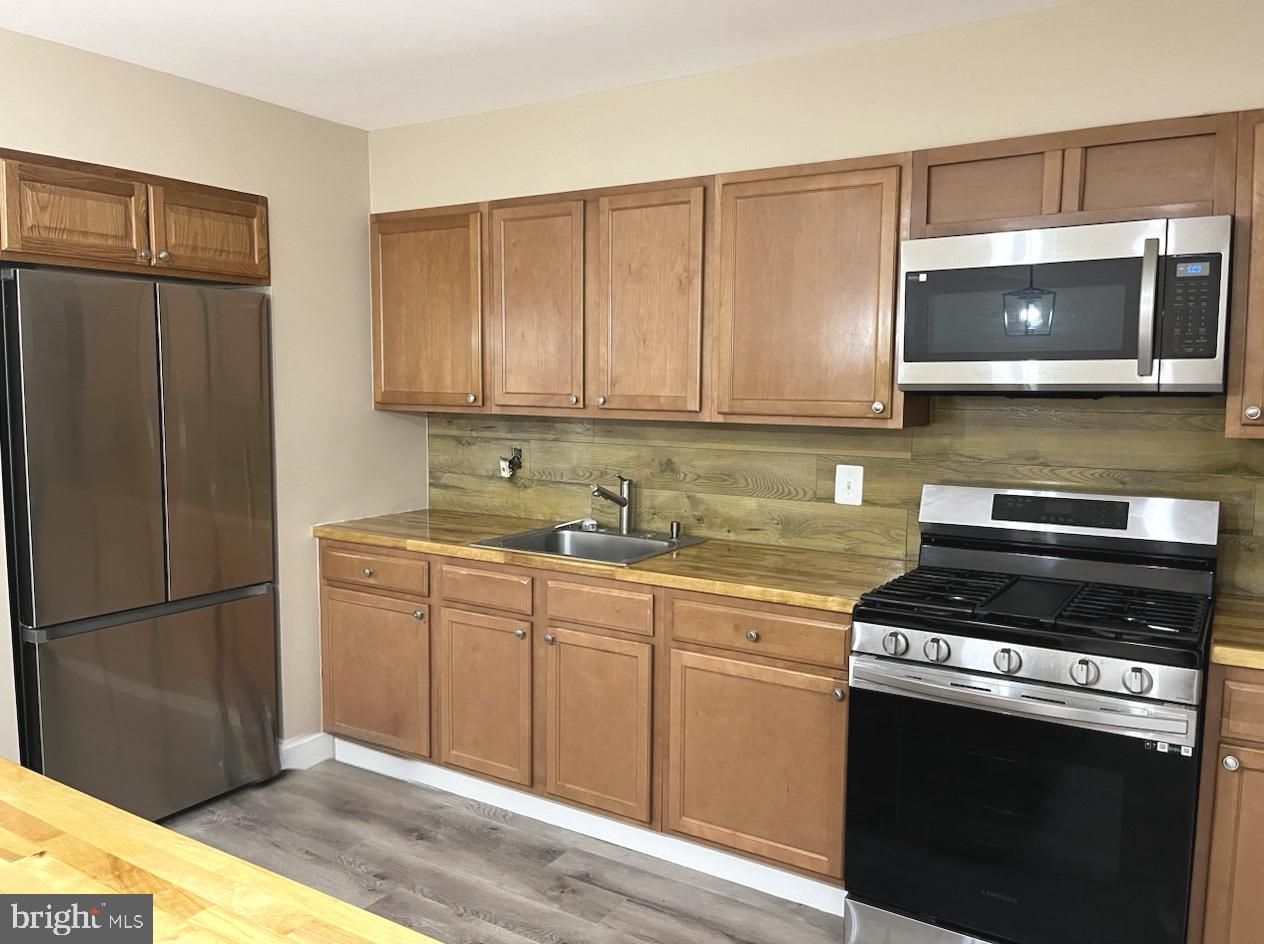 4865 Melbourne Road Baltimore, MD 21229 - Photo 2 of 19 a kitchen with stainless steel appliances granite countertop a stove a microwave and a refrigerator