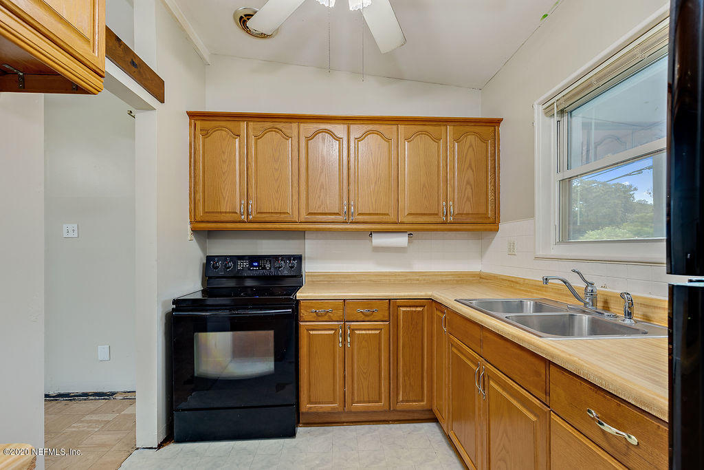 10453 Agave Road Jacksonville, FL 32246 - Photo 12 of 23 a kitchen with granite countertop a sink stove and cabinets