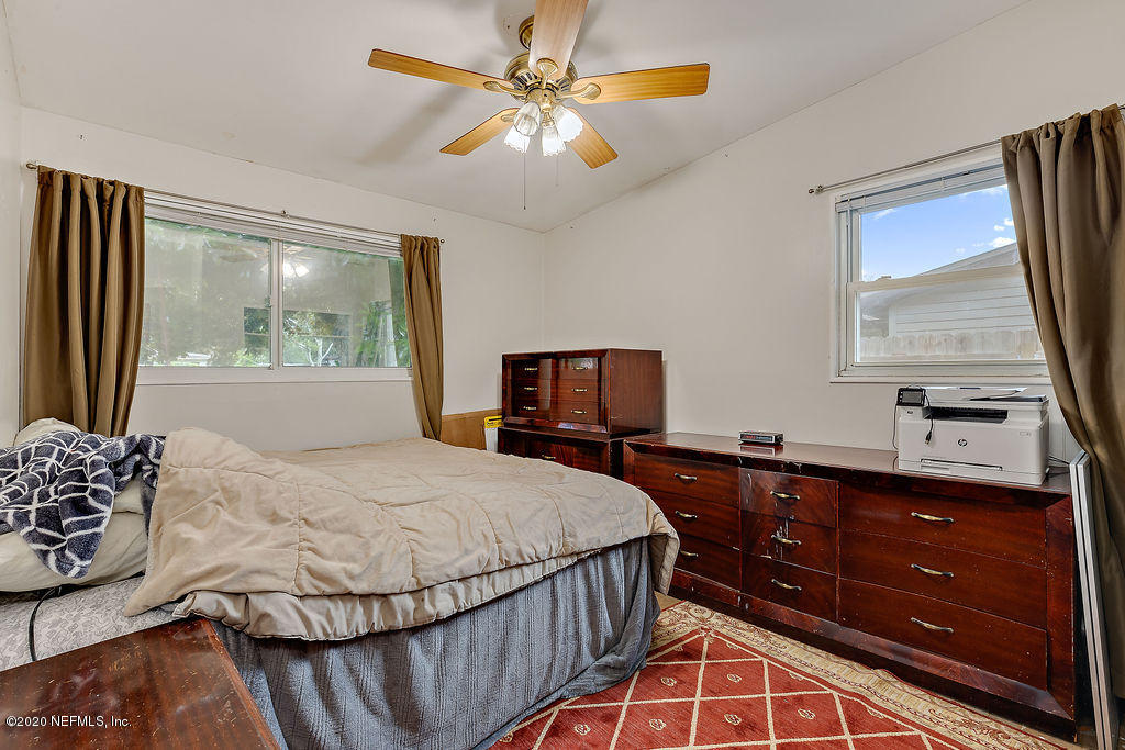 10453 Agave Road Jacksonville, FL 32246 - Photo 16 of 23 a bedroom with a bed and a dresser with the outer view