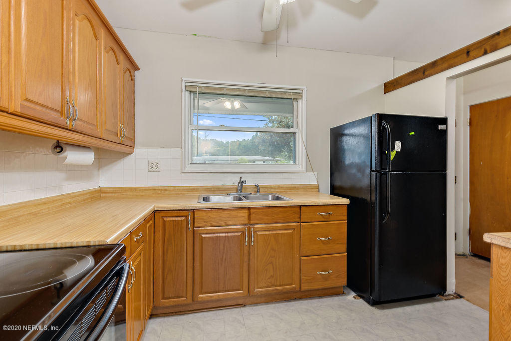 10453 Agave Road Jacksonville, FL 32246 - Photo 10 of 23 a kitchen with a refrigerator and a sink