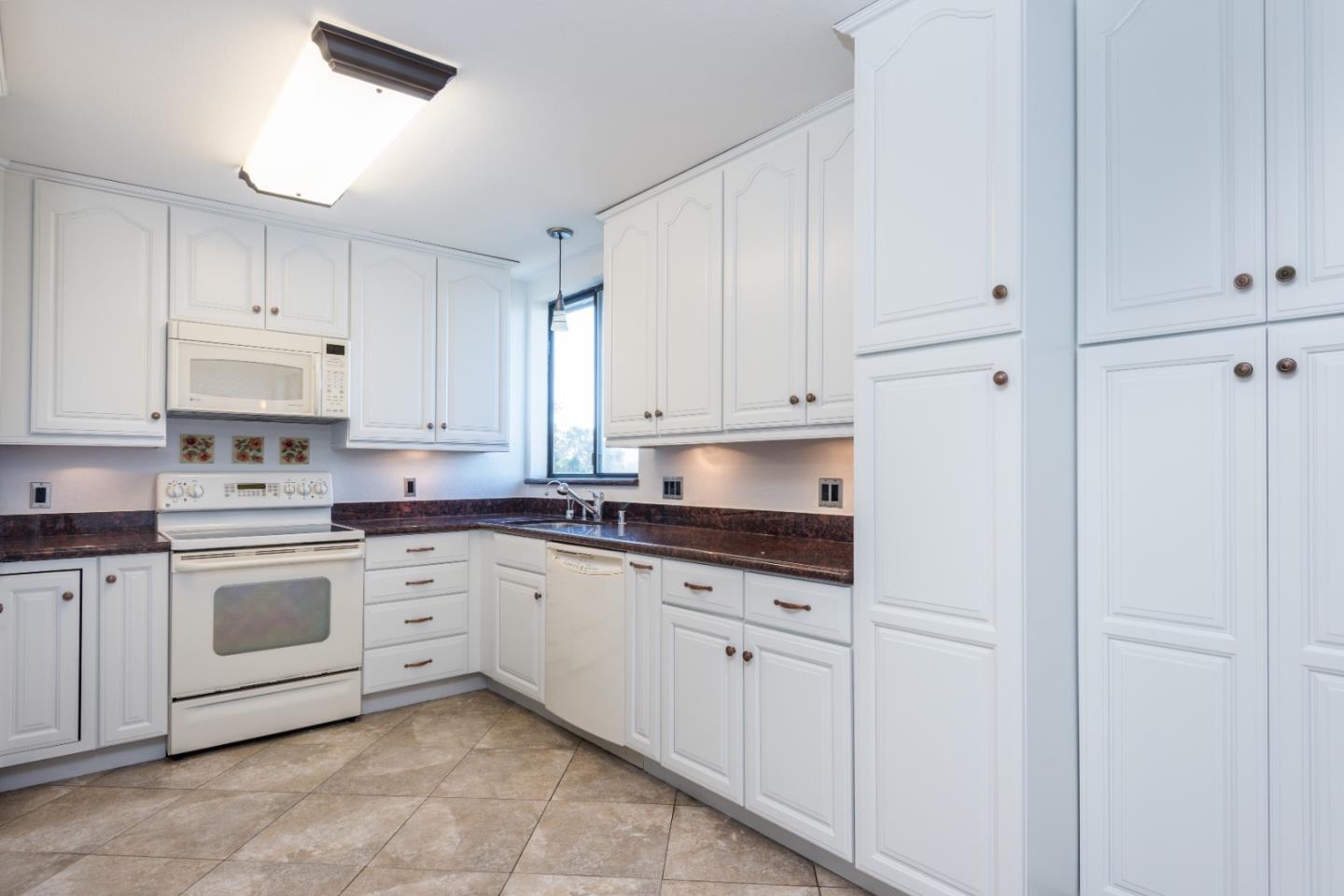 425 Anchor Road, Unit 317 San Mateo, CA 94404 - Photo 11 of 35 a kitchen with granite countertop white cabinets and white appliances