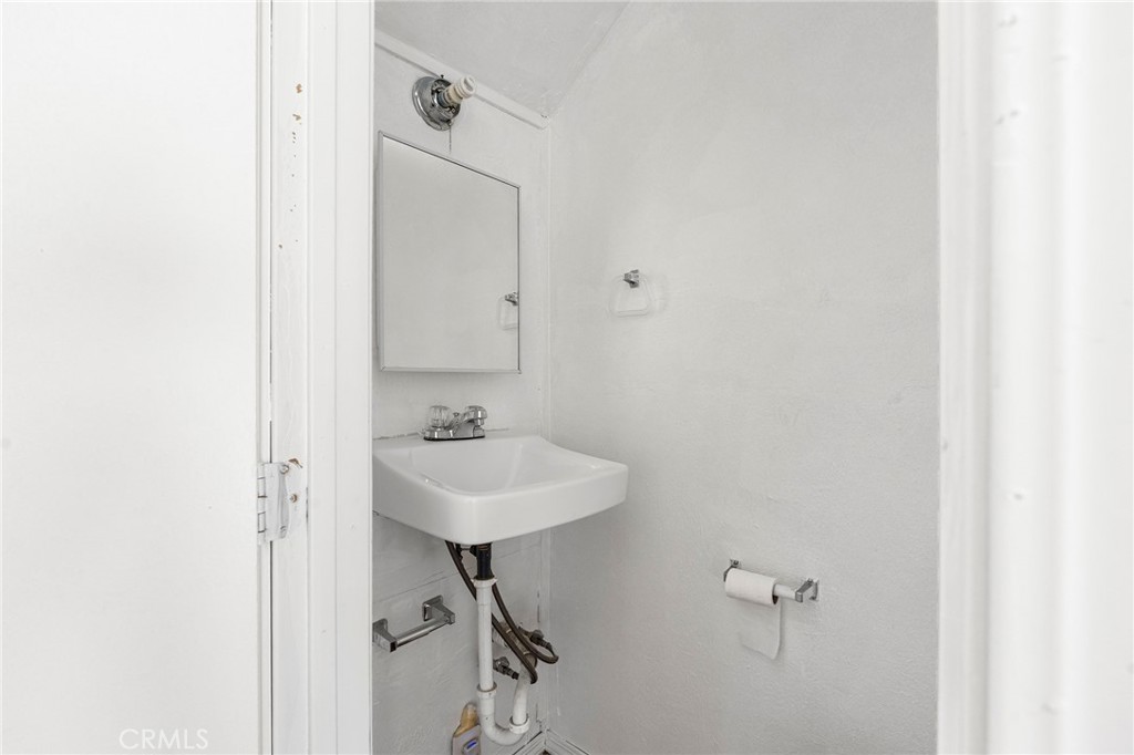 818 6th Street Corning, CA 96021 - Photo 23 of 32 a bathroom with a sink a mirror and a toilet